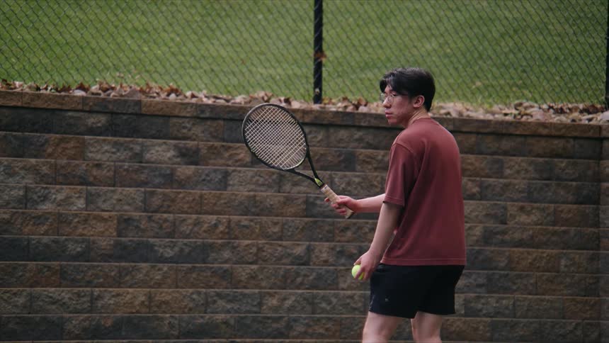 A tennis player serving the ball then failing to catch the ball