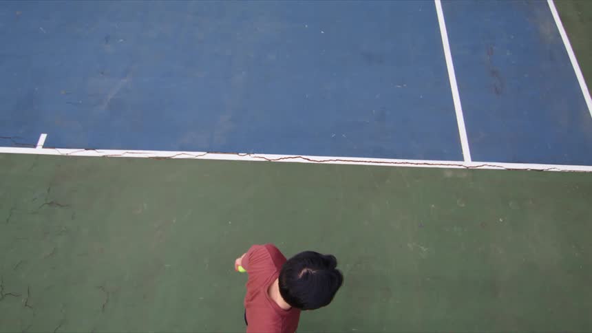 A man hits a tennis ball with a racket