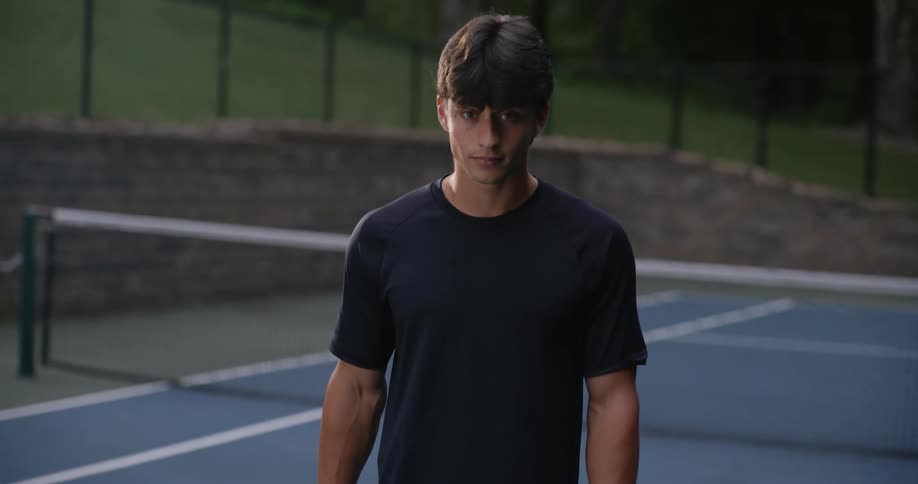 Man holding a racket while standing on a tennis court