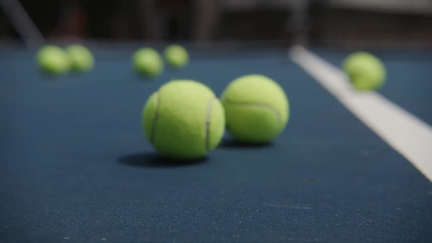 A tennis racket swats a tennis ball away