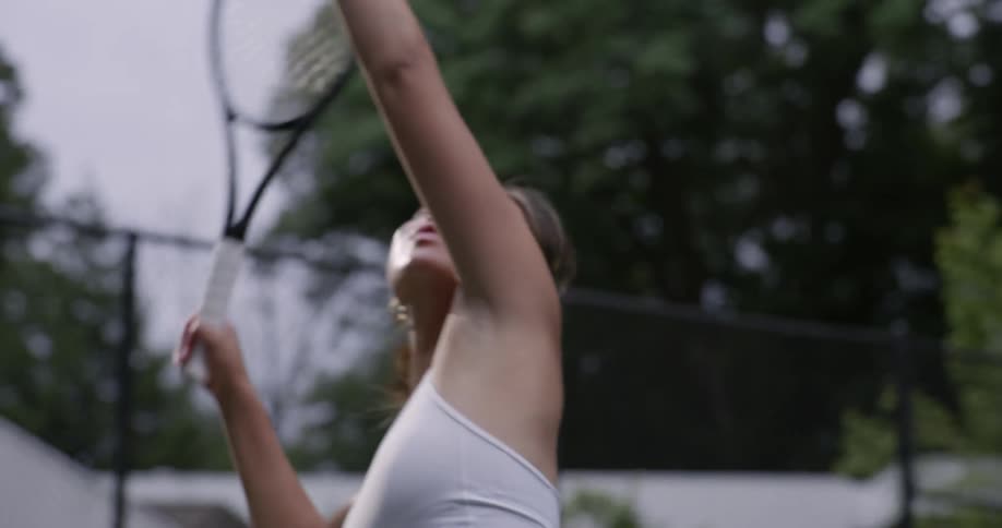 A woman serves the tennis ball