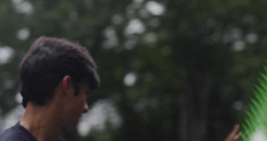 A man plays aggressive tennis on a court in a park
