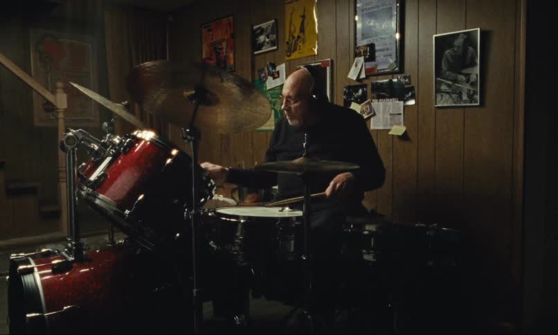 Older Man playing drums in basement