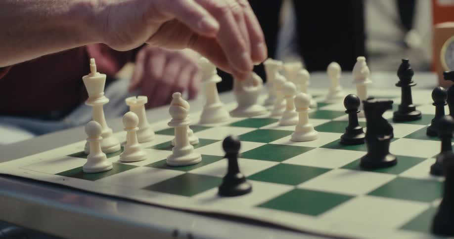 Man moves chess pieces on a board before hitting a timer