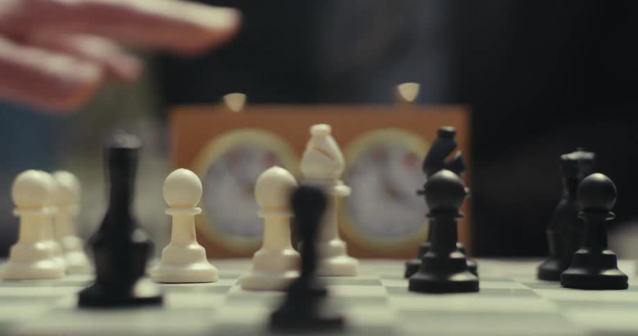 Two people play chess with a timer