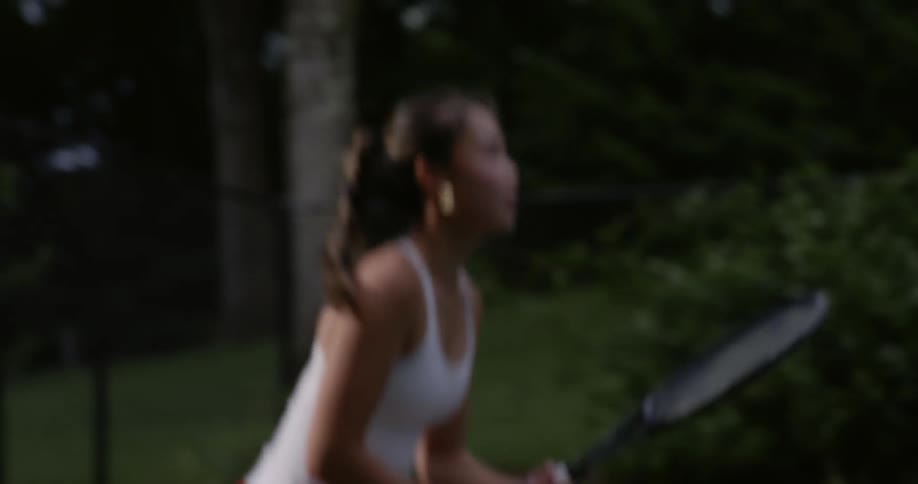 A woman is playing tennis and hitting the ball with a racket