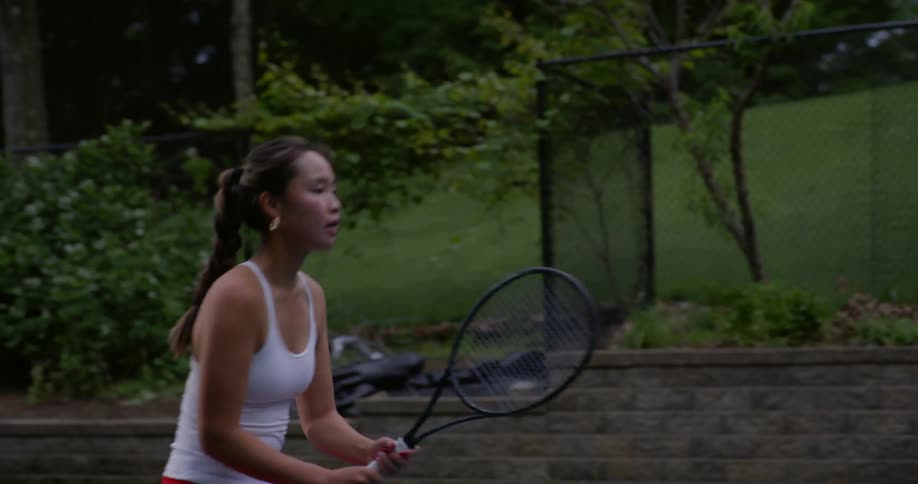 A woman using a racket to play tennis and she is close to the courts dividing net