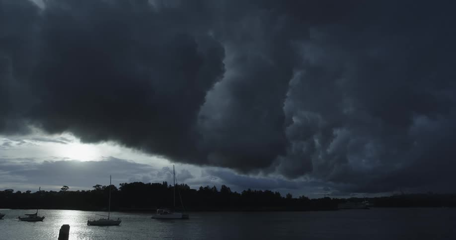 Boats floating in the lake under a stormy sky