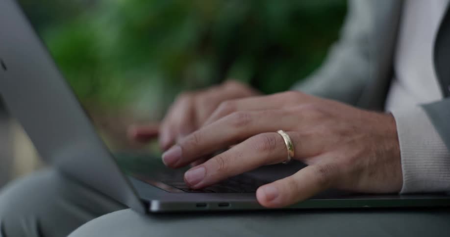 Pair of hands of a man typing on a laptop