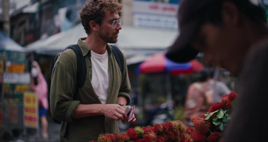 Man buying fruit in at an asian street market