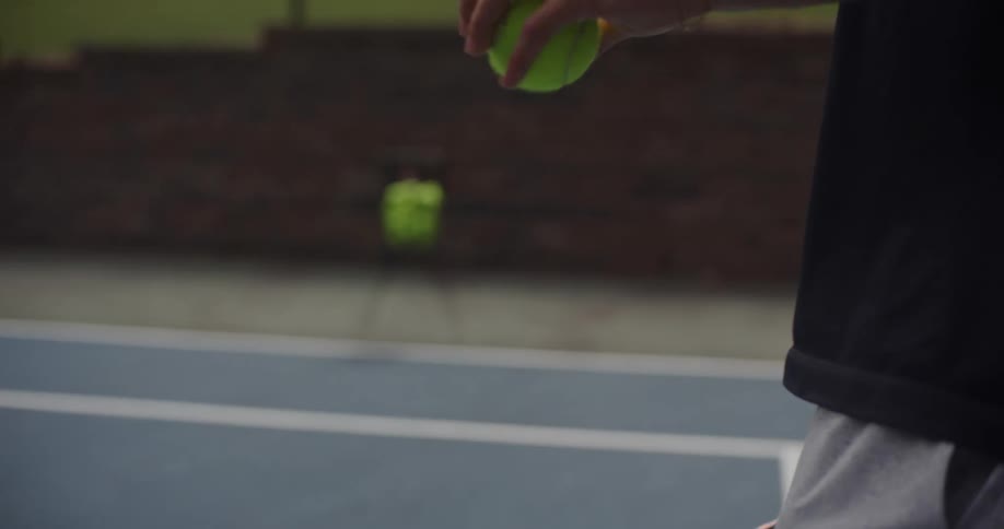 Boy with a racket and a tennis ball on a court