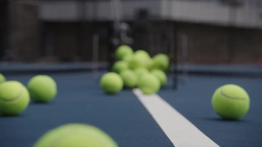 Greenish tennis balls falling on the court