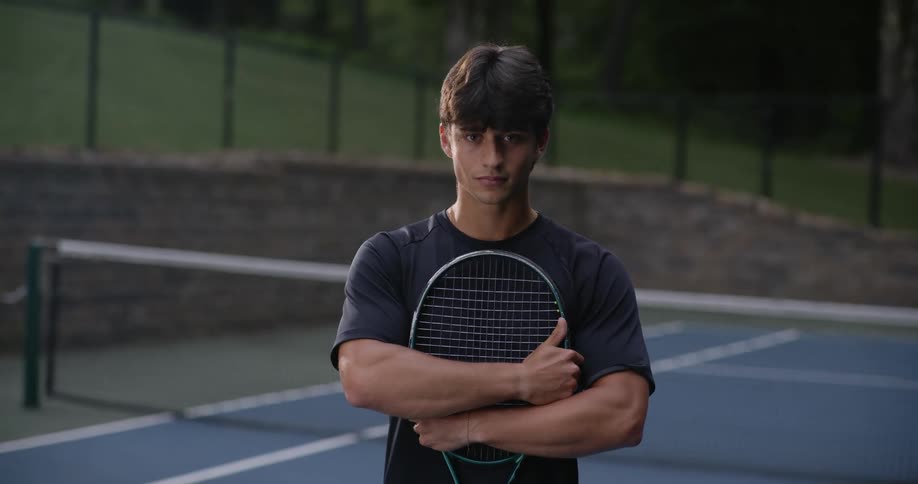 A man holds his tennis racket on the court