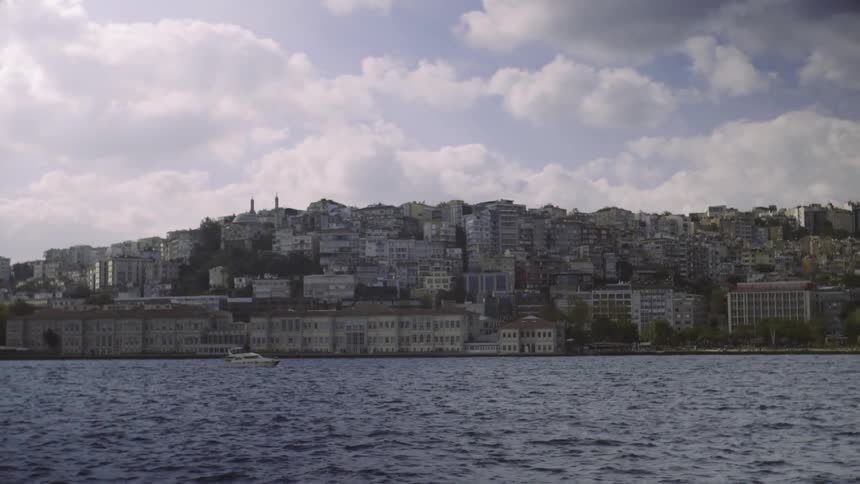 View of a large city next to a body of water on a cloudy day