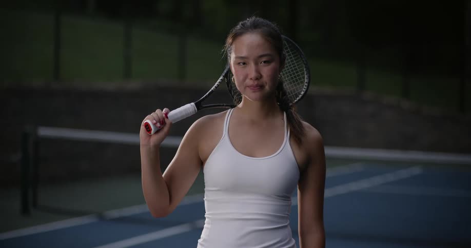 Young woman on a court pointing her tennis racket forward