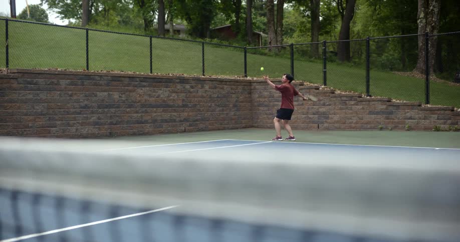 Teenager playing tennis on an open court