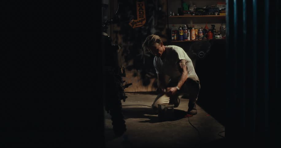 A young man works to fix a motorcycle in a garage