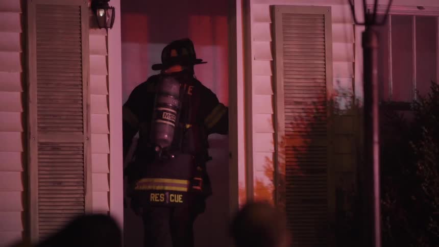 Couple watched as a firefighter enters a house