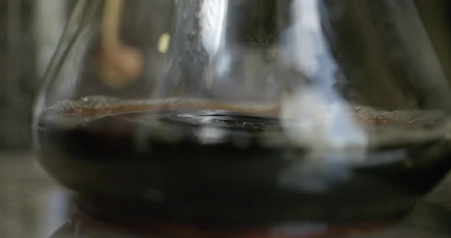 A dark liquid drips into a carafe