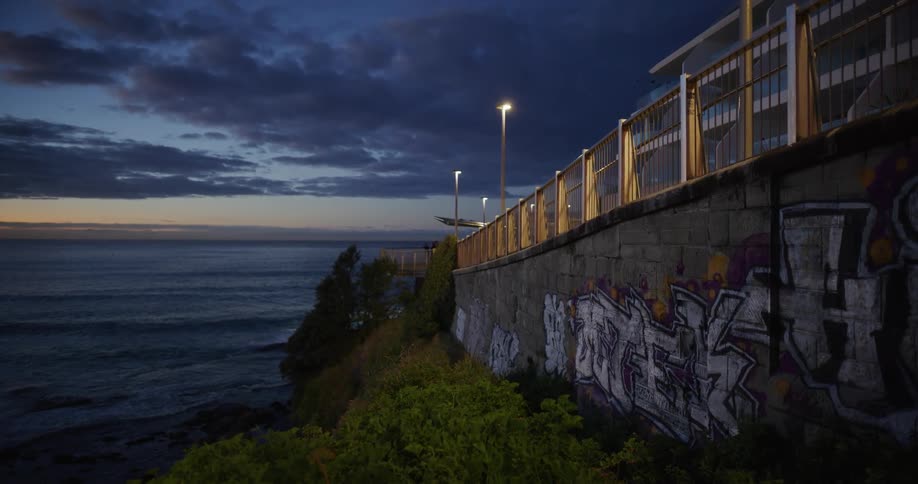 Wall of a coastal hotel covered in grafitti near the coast at sunset