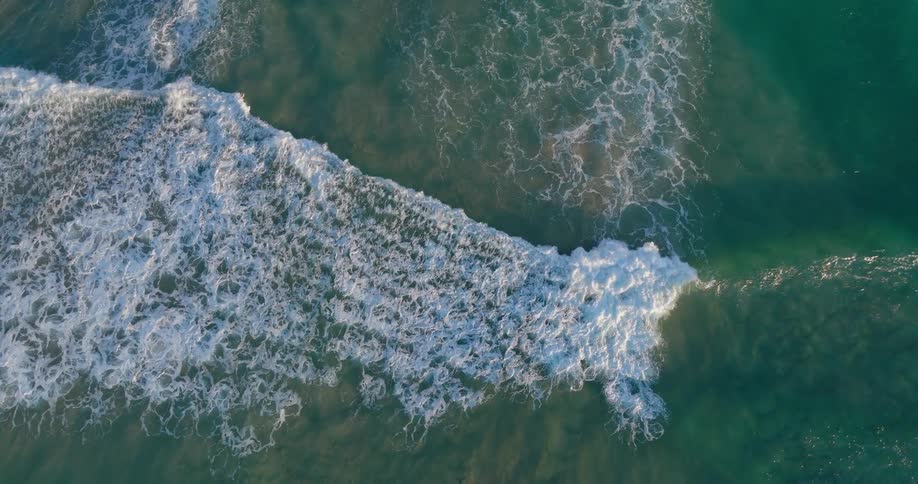 Aerial view of foamy waves on a beach