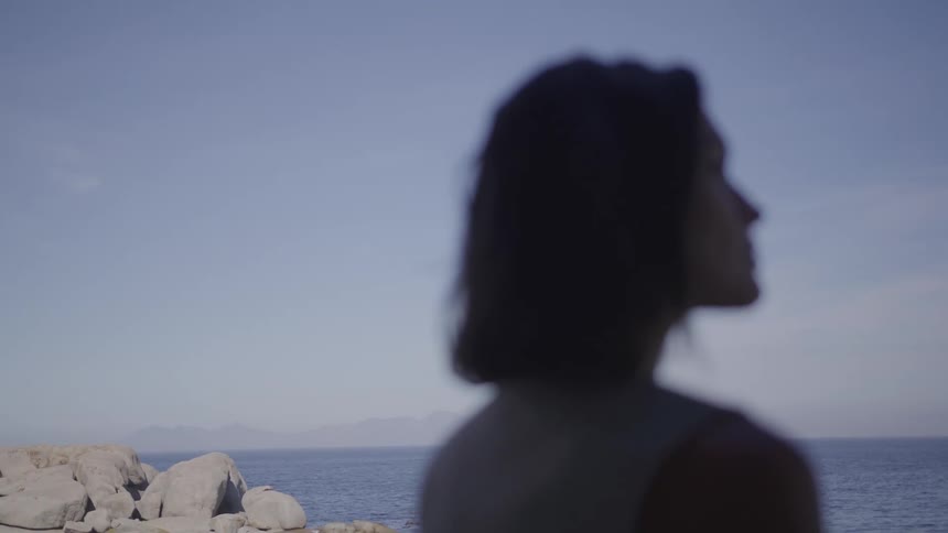 A woman looks out over the ocean