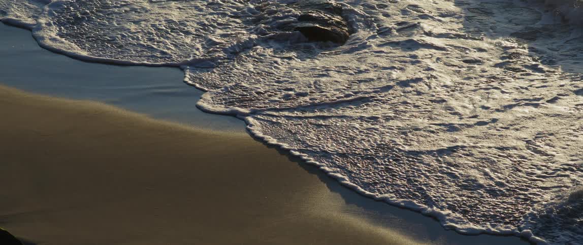 Foamy waves crashing onto the sand