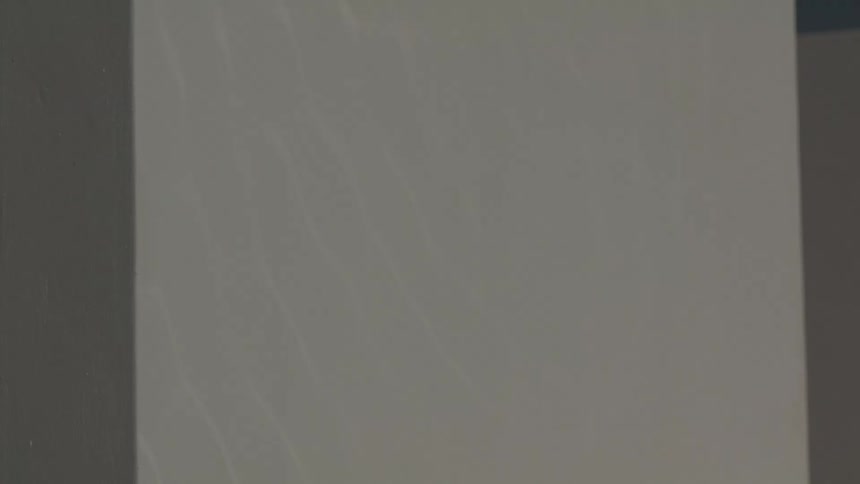 A movement of some white lines moving in a square of a white wall