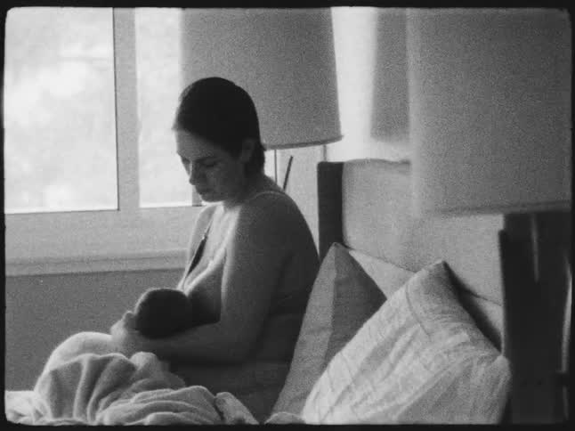 Mother sitting on the couch breastfeeding her baby