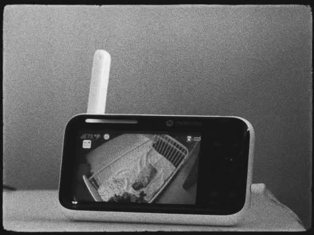 Screen of a camera showing a baby sleeping in the crib