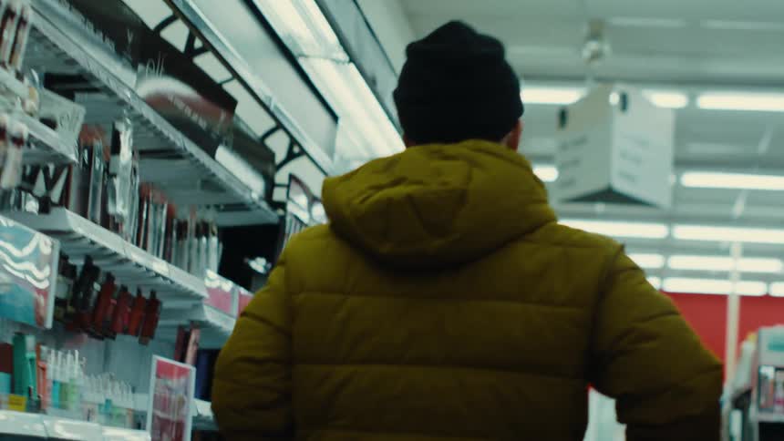 Man walking down a pharmacy aisle