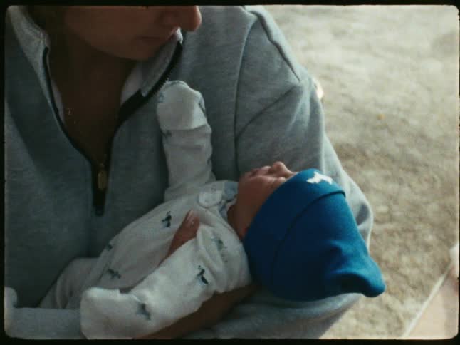 Mother picks up baby while in living room at home