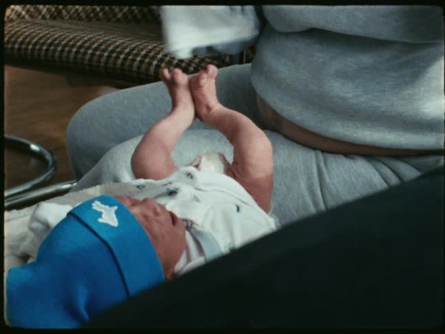 An adult readies to change a babys diaper