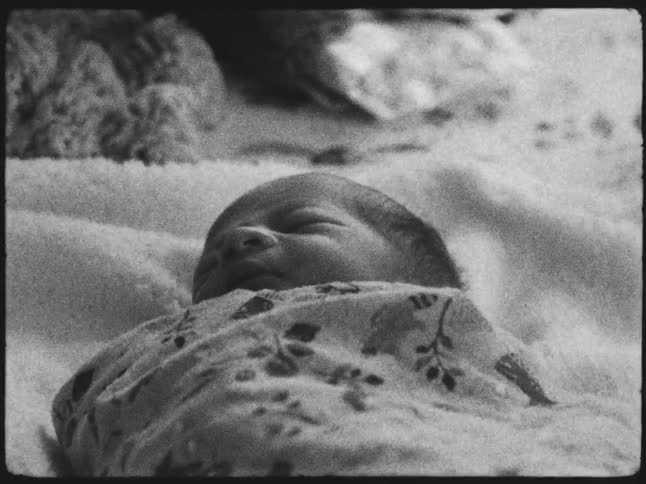 Newborn baby is wrapped in a patterned blanket