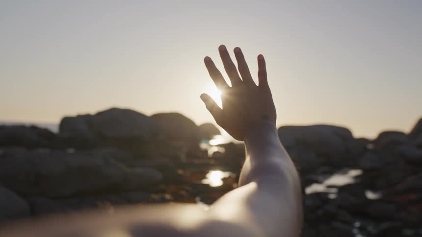 Womans hand against the morning sun