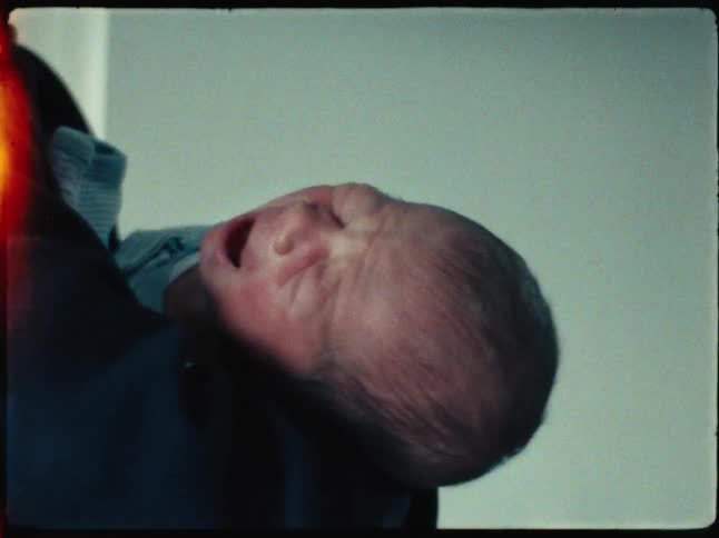 Newborn baby crying on someones lap