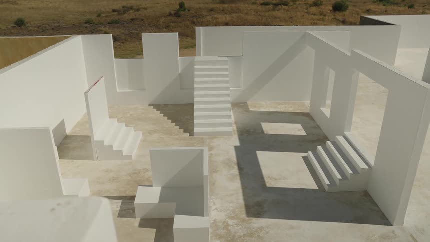Unfinished structure of stairs and white walls in a field
