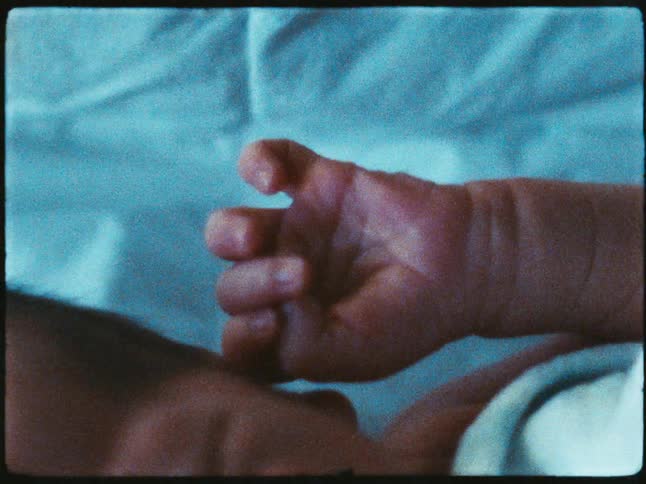 Small baby moves its tiny hand in its sleep