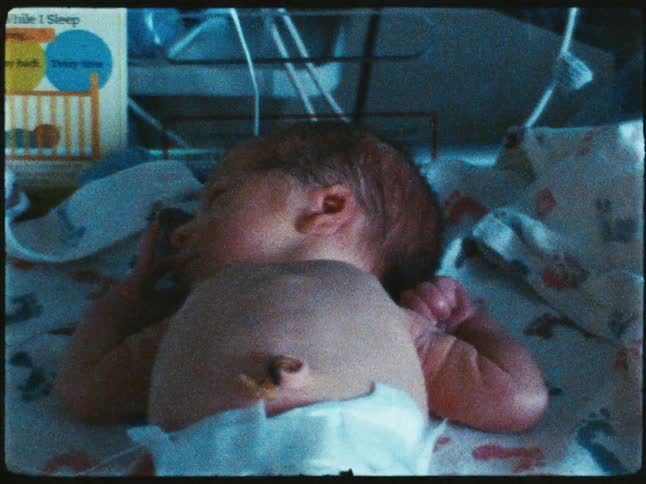 A newborn sleeps peacefully in a crib with soft ambient lighting