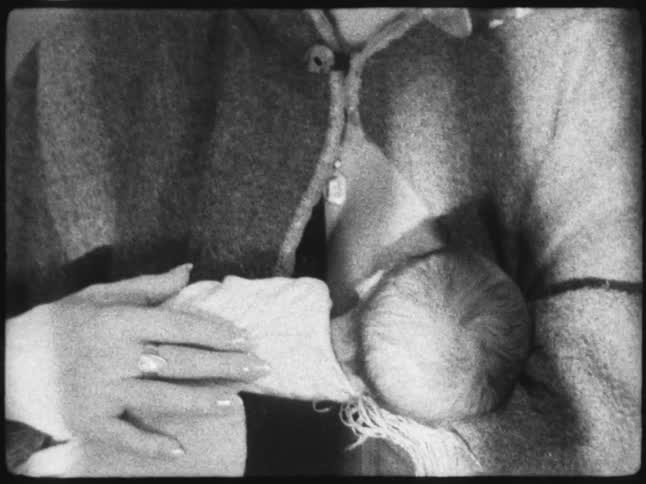 A woman holding a newborn in her arms caught on vintage black and white film