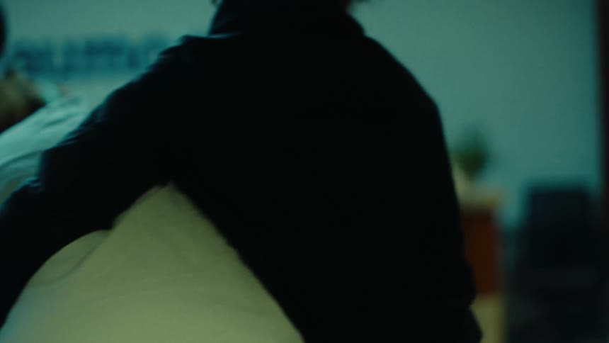 A closeup of a person walking with a pillow tucked in between their arm