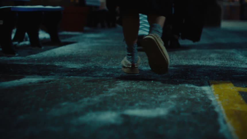 Legs of a person walking on a street at night