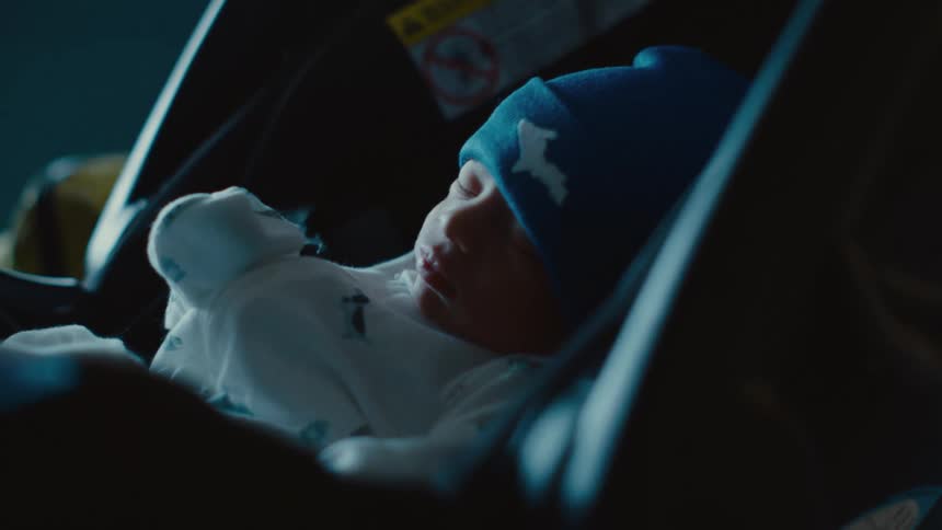 Baby sleeping in a carrier in a dark environment