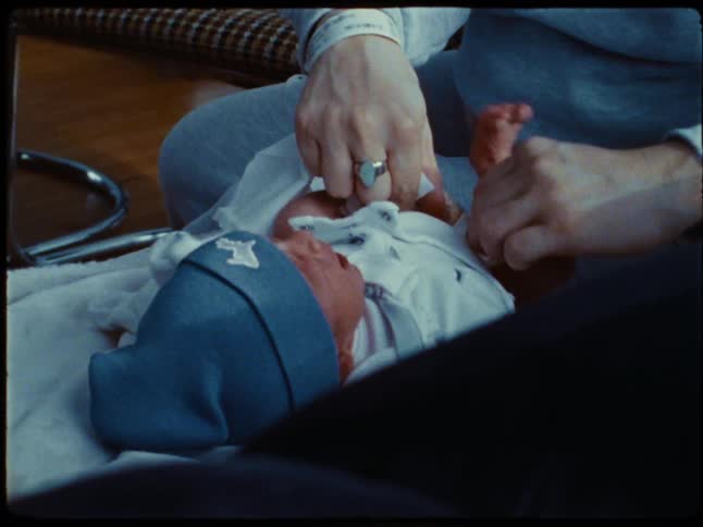 Mother changing newborn babys diaper