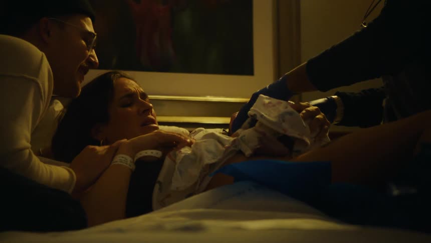 Emotional father and mother with a newborn baby in their arms and a doctor at their side