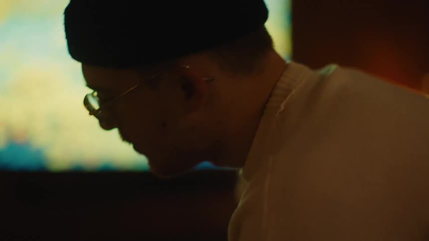 A young man wearing a toque bobs his head to the music