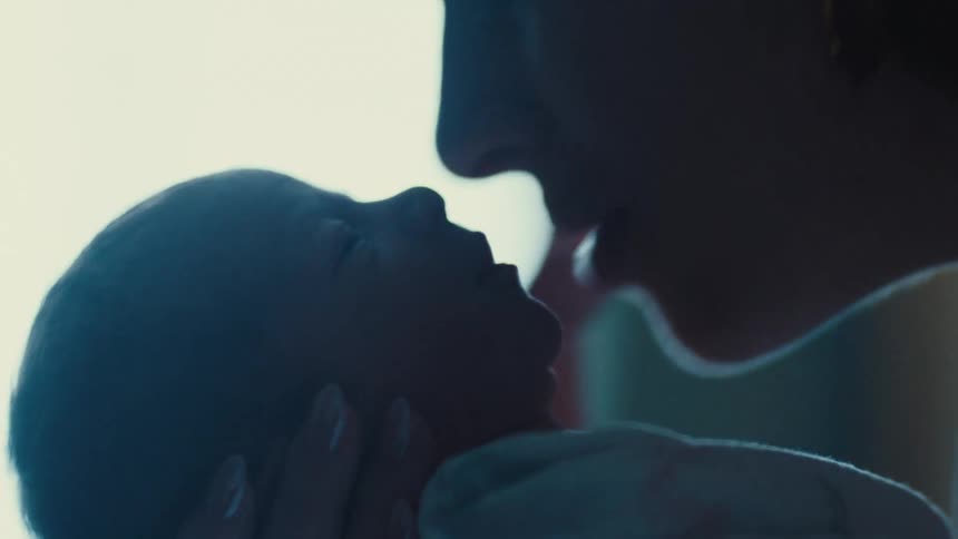 Portrait of a mother giving her newborn baby a kiss