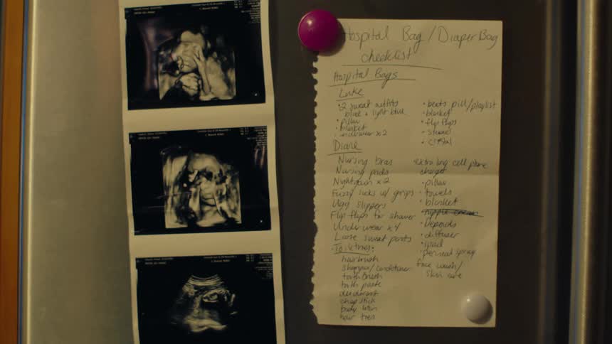 An ultrasound and list is attached to the fridge with magnets