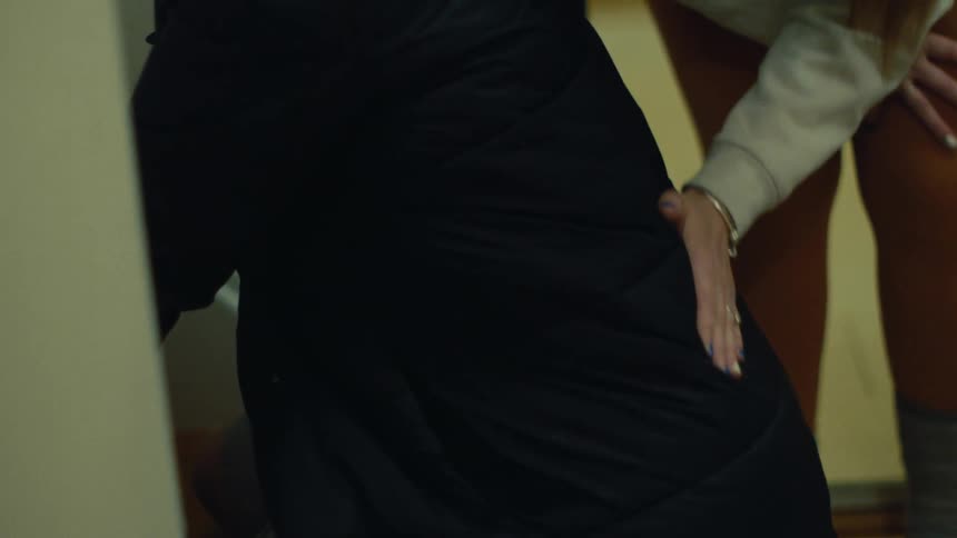 Woman massaging the back of another woman who is squatting