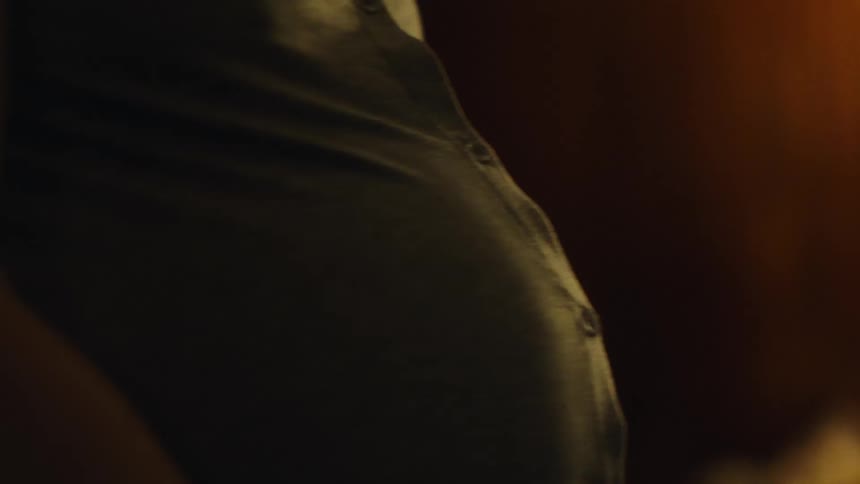The belly of a woman who is pregnant and it is moving from side to side